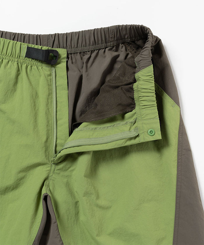 Close-up view of jade green Gramicci Nylon Block Shorts on a light-tone background.