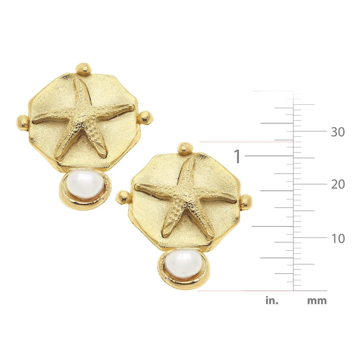 Gold earrings with starfish and pearl design, accompanied by a measurement scale.