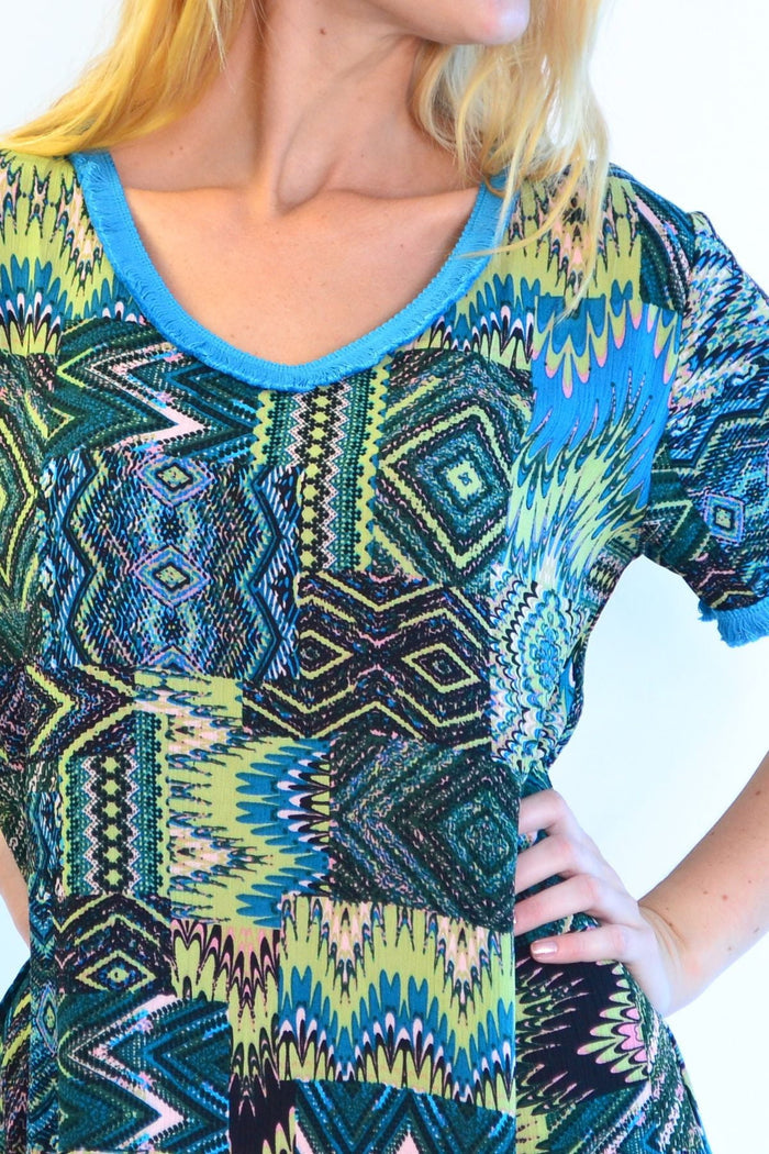 Blue tasseled Cha Cha Crinkle Tunic Shift Dress by Zen Garden displayed on a hanger, showcasing its relaxed fit and textured fabric.