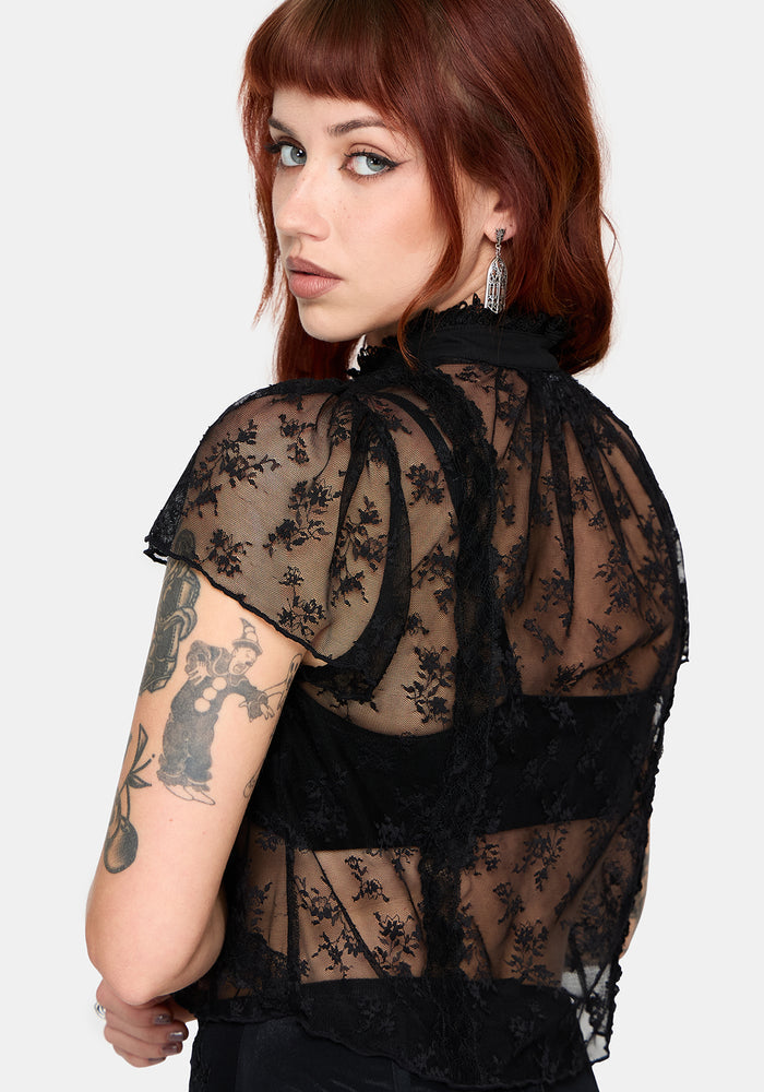 Woman wearing a black lace top against a white background