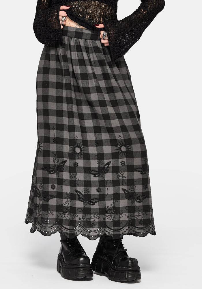 Woman wearing a black and gray checkered skirt with lace details on a white background