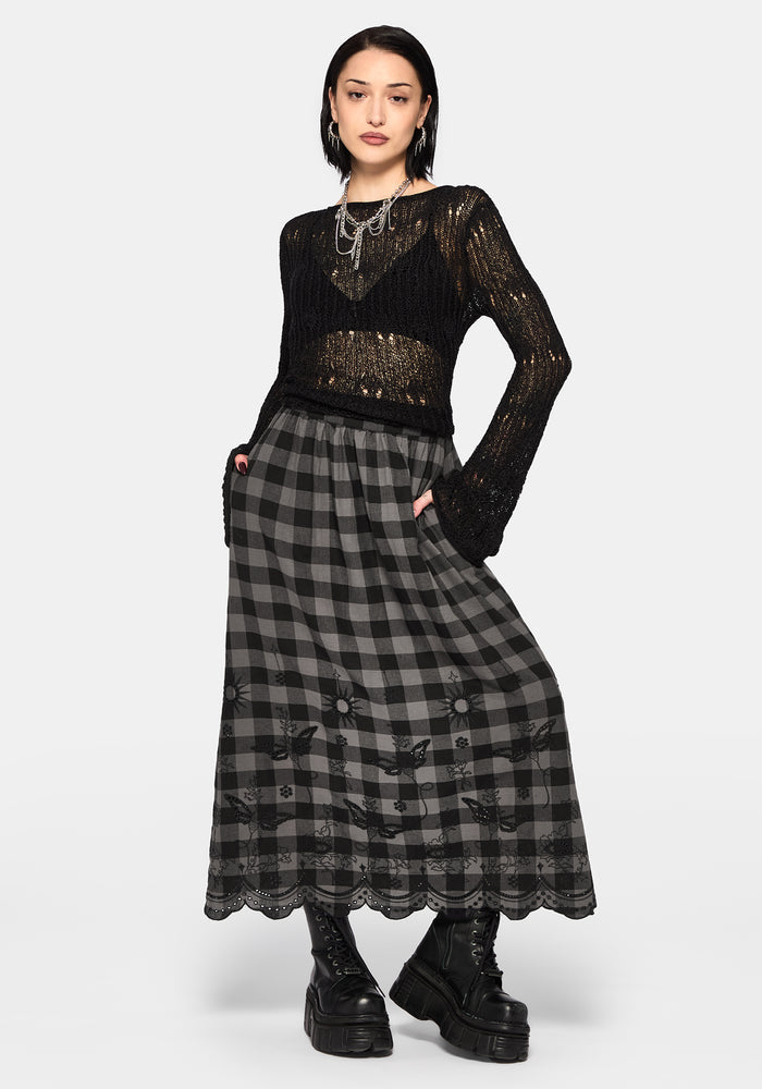 Woman wearing a black and gray checkered skirt with lace details on a white background