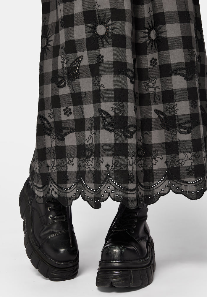 Woman wearing a black and gray checkered skirt with lace details on a white background