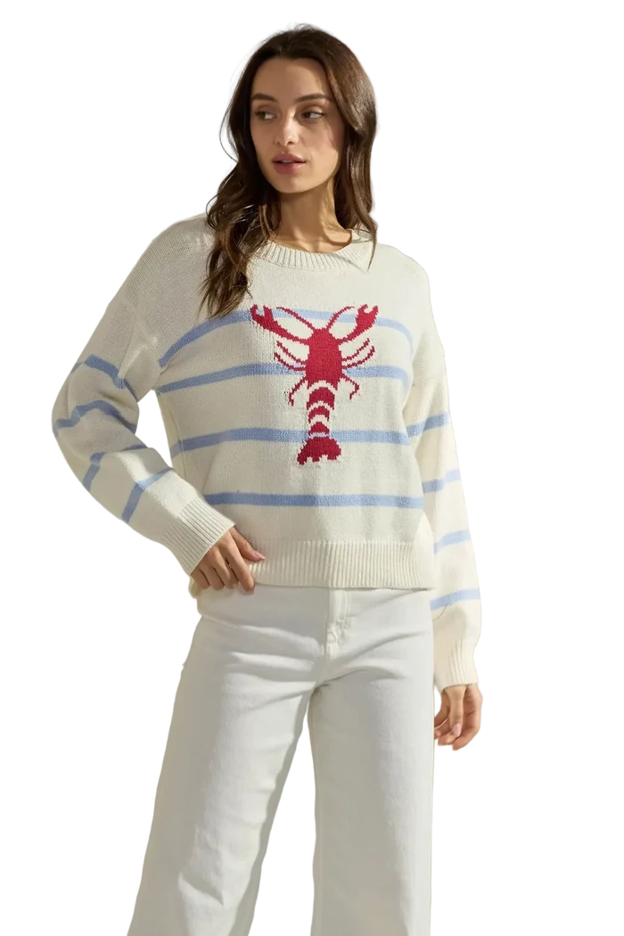 Woman wearing a sweater with a red lobster design on a plain background