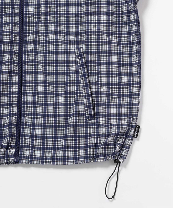 Gramicci navy Checkered Shell Jacket hem detail with drawstring against a light-tone background.