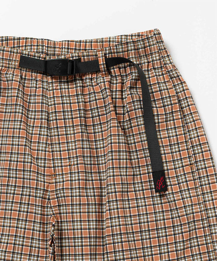 Close-up view of brick check colored Gramicci Checkered Shell Shorts on a light-tone background.