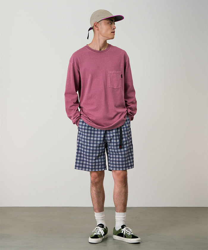 Model wearing navy check colored Gramicci Checkered Shell Shorts and a red shirt on a light-tone background.
