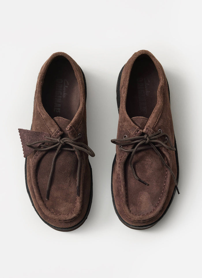 A top-down shot of the Percival x Clarks Originals Meare Walla shoes in dark brown suede, on a white background.