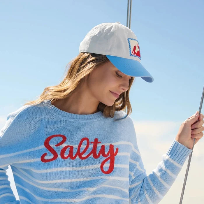 Person wearing a 'Salty' sweater on a boat with ocean view