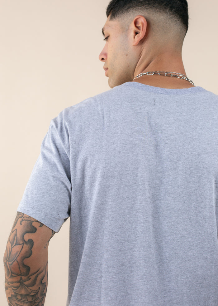 backside of man wearing oversized deadstock tee in heather grey