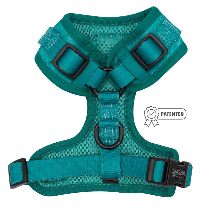 The Sassy Woof Dog Adjustable Harness - Napa features a teal mesh design, sturdy adjustable straps with black buckles, and brand labeling. A patented badge icon is displayed beside the harness.