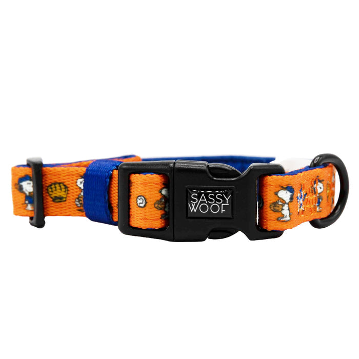The Sassy Woof Dog Collar - MLB™ x Peanuts™ Houston Astros™ features playful cartoon dog faces and paw prints, a black Sassy Woof buckle, and a blue strap—perfect for fans seeking a fun, adjustable collar.