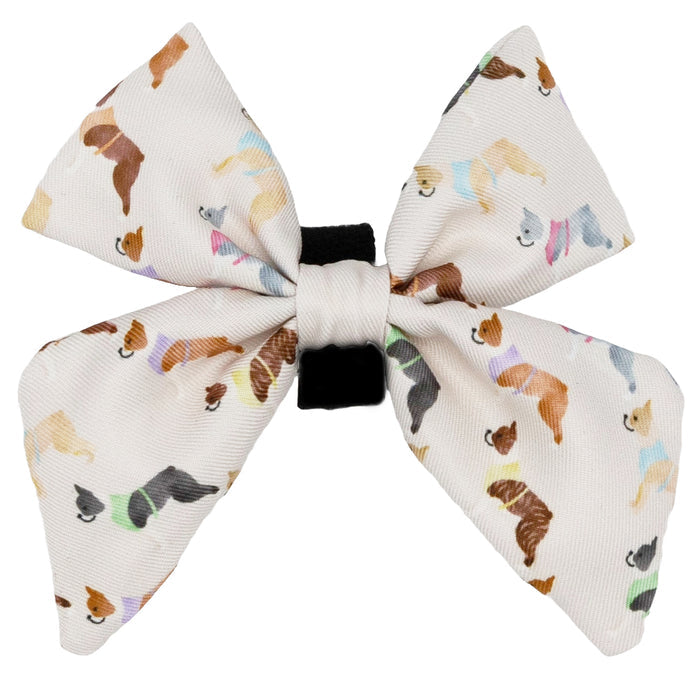 The Sassy Woof Dog Sailor Bow - Bold Boston Terriers is a cream-colored fabric bow with playful dog-in-sweater prints and a black elastic band for easy collar attachment, part of the Boston Terrier Collection.