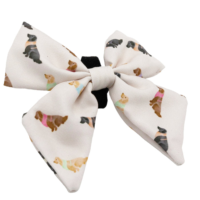 The Sassy Woof Dog Sailor Bow - Loyal Labradors is a white bow featuring colorful labrador patterns—an adorable accessory to pair with your pup’s favorite collar or adjustable harness.