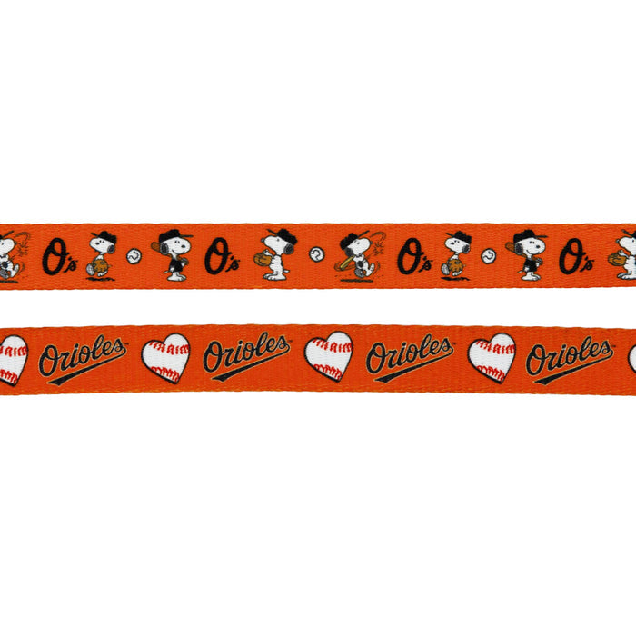 This Sassy Woof Dog Leash - MLB™ x Peanuts™ Baltimore Orioles™ has two orange ribbons: one with Snoopy & Woodstock in baseball gear with Os/baseballs, and another with hearts, bats, and Orioles in black/orange.