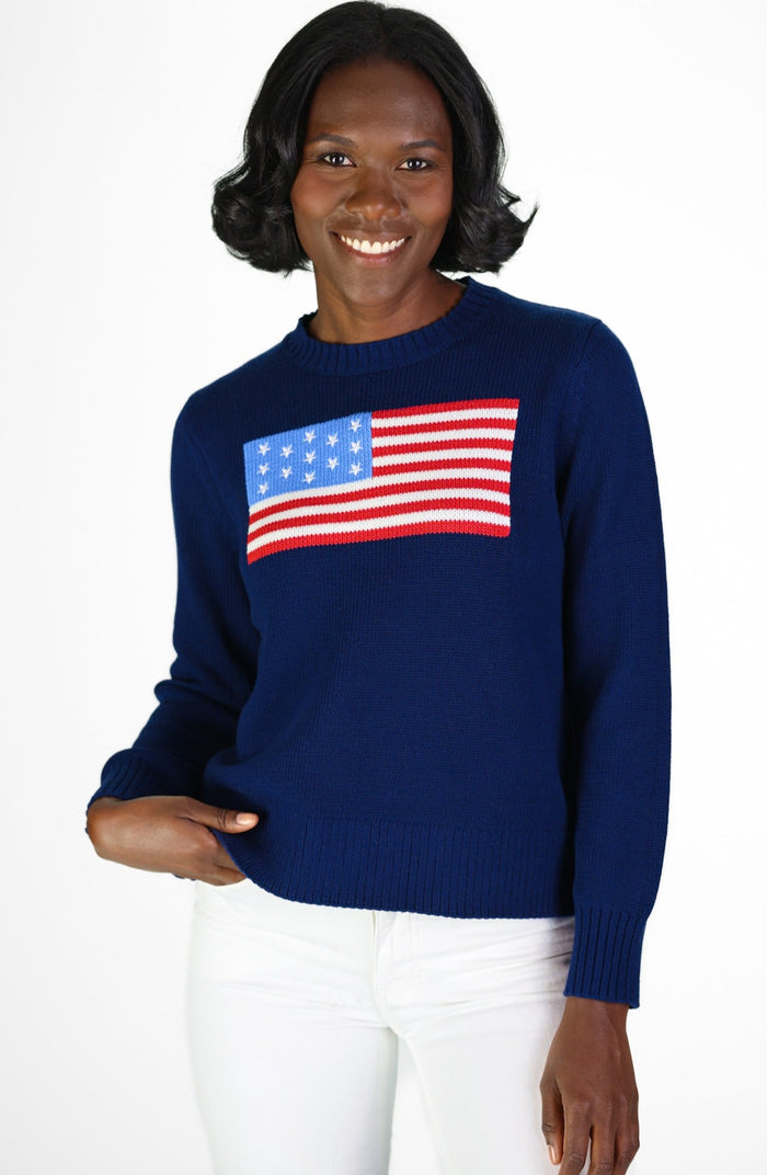 Woman wearing navy sweater with US flag design on a white background