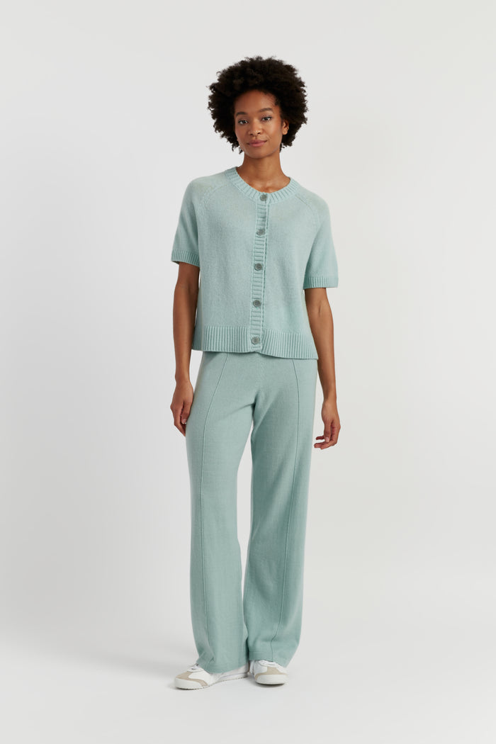 Person wearing a light green outfit on a white background