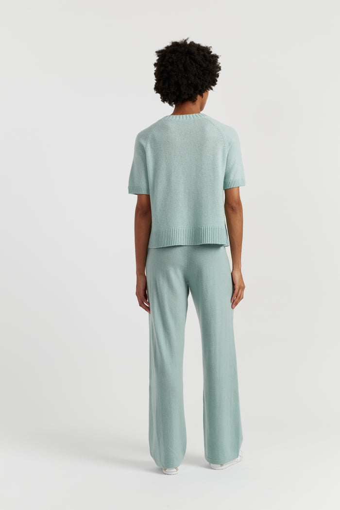 Person wearing a light green outfit on a white background