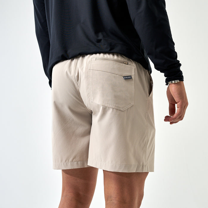 Person wearing beige shorts and a black long-sleeve shirt on a white background