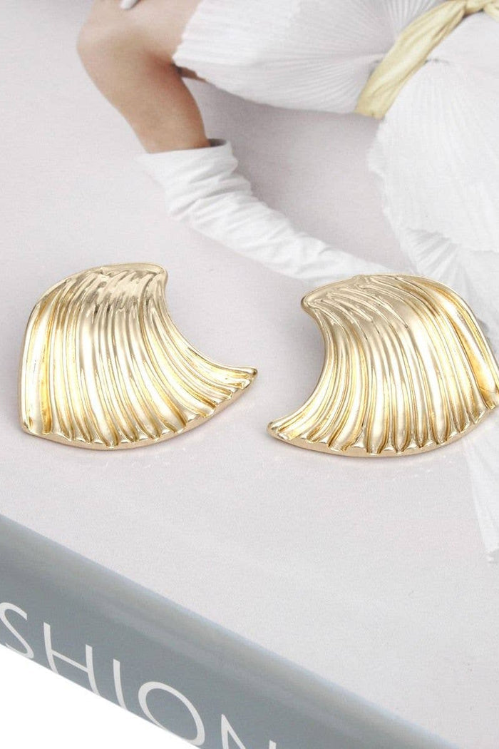 Polished gold ocean wave stud earrings with a sculpted curved metal design.