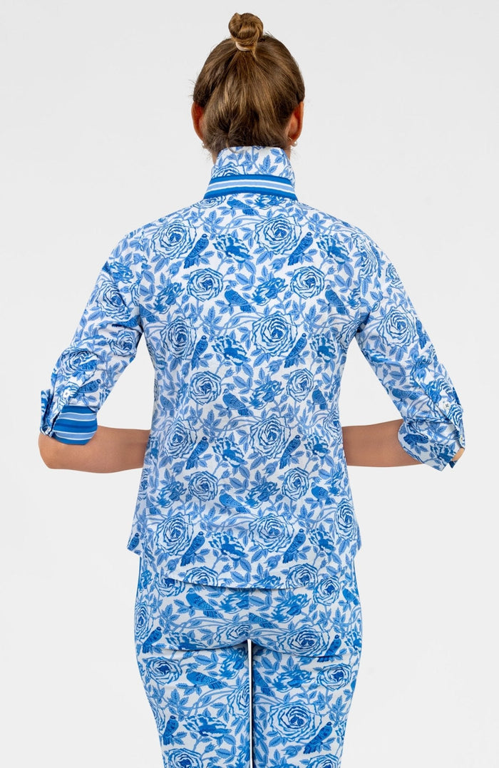 Woman wearing a blue and white patterned shirt with blue trim with matching pants on white background