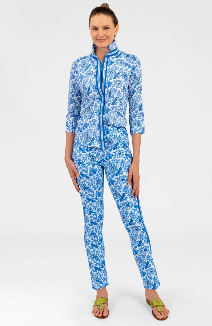 Woman wearing a blue and white patterned shirt with blue trim with matching pants on white background