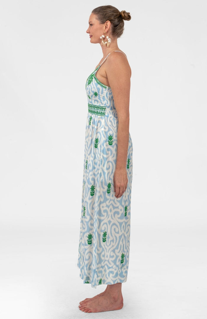 Woman wearing a long, patterned dress on a white background