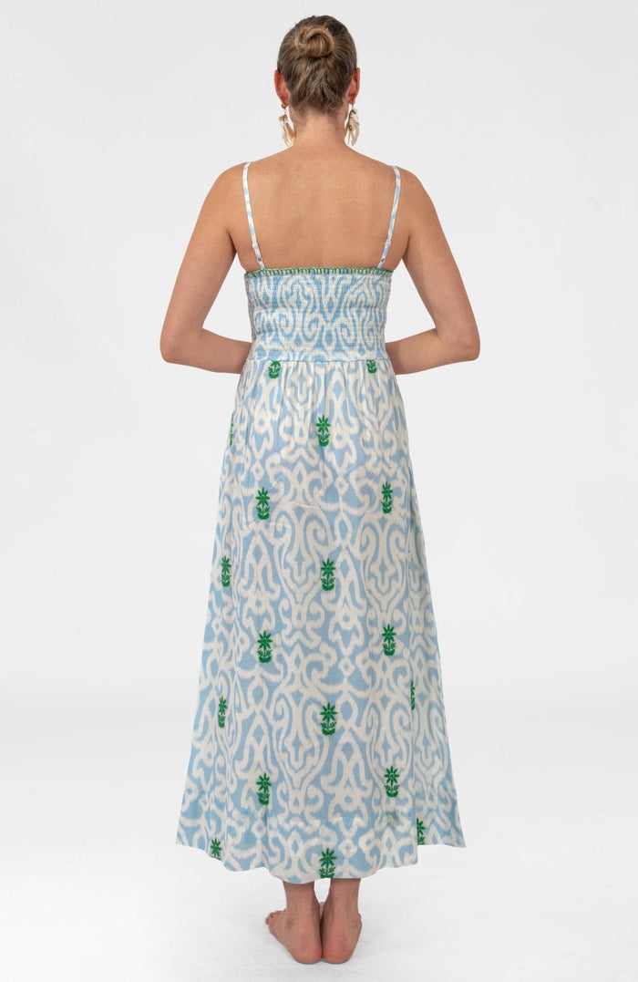 Woman wearing a light blue patterned dress on a white background