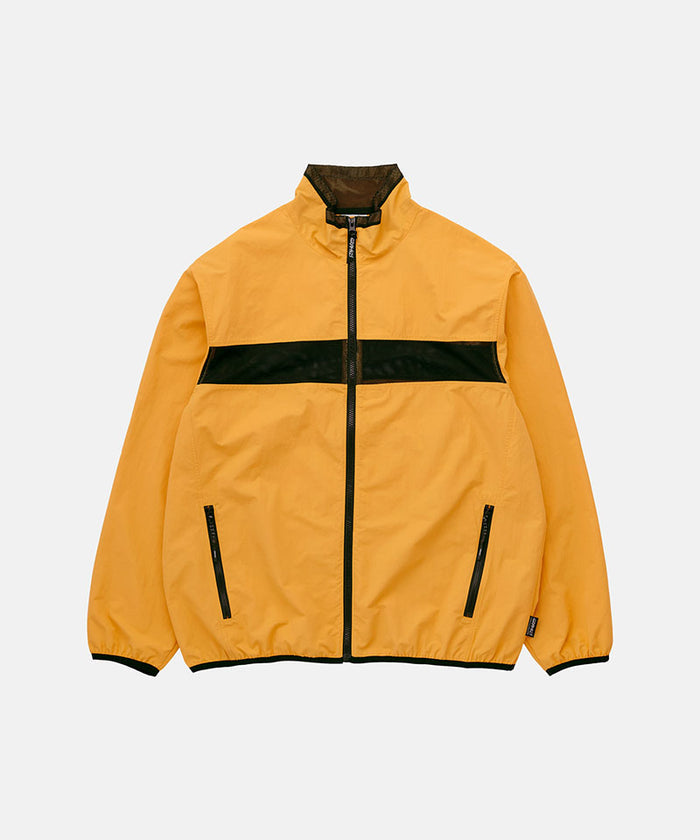 Gramicci mango colored Gramicci Guide Jacket against a light-tone background.