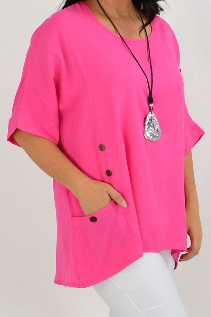Hot pink Wishstone coconut button tunic top with sloping sleeves, shown on a model, featuring a relaxed fit and stylish design.