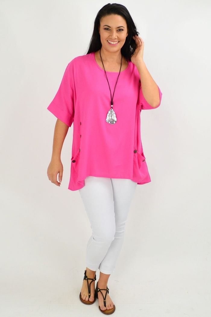 Hot pink Wishstone coconut button tunic top with sloping sleeves, shown hanging on a white background.