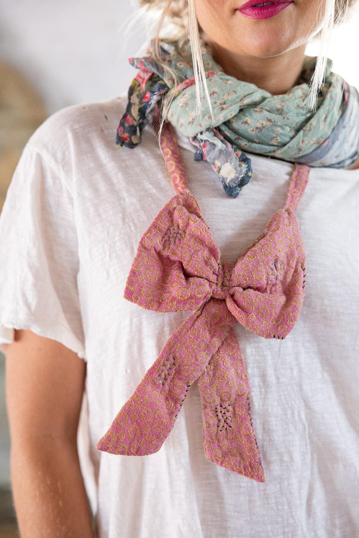 Magnolia Pearl vintage pink artisan bow necklace and floral scarf on white shirt, whimsical style