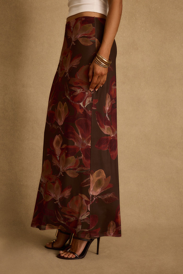Side view of the mulberry floral mesh maxi skirt styled with a white crop top, gold bangles and black heels.