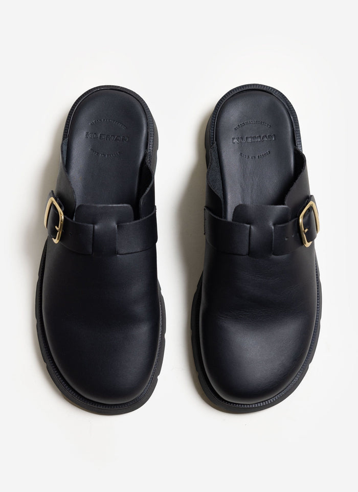 A top-down view of the black leather Kleman Pacha sandals with gold buckles, available at Percival.