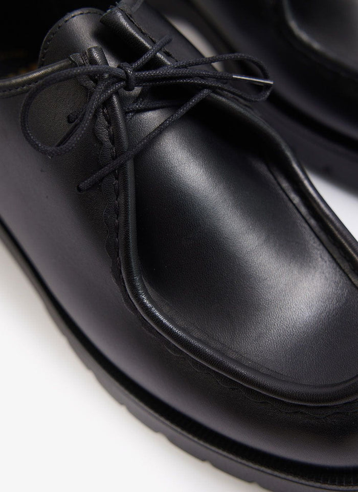 Close-up of the black leather Percival Kleman Padror shoe, highlighting the distinctive serrated stitching and laces.
