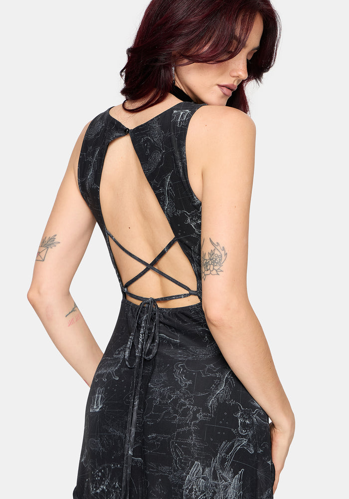 Woman wearing a black printed sleeveless dress with a belt on a white background