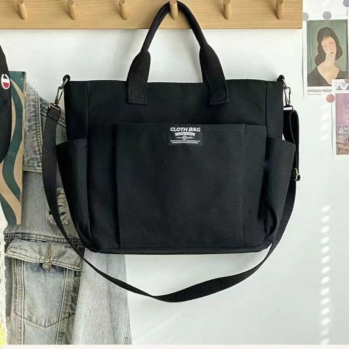 Beige canvas shoulder bag, for women with top handles, adjustable strap and front pocket shown for daily work and travel use.