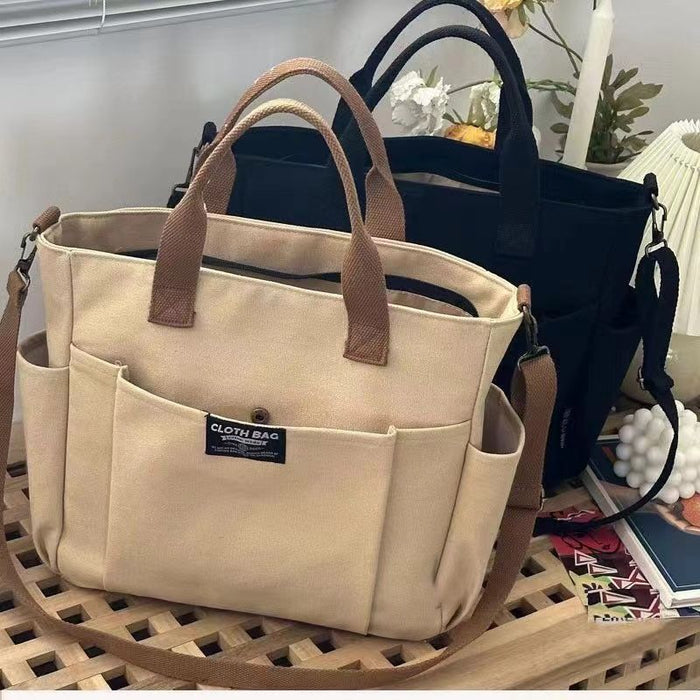 Canvas shoulder bag with polyester lining, top handles, adjustable strap and front pocket shown in the detailed product view.