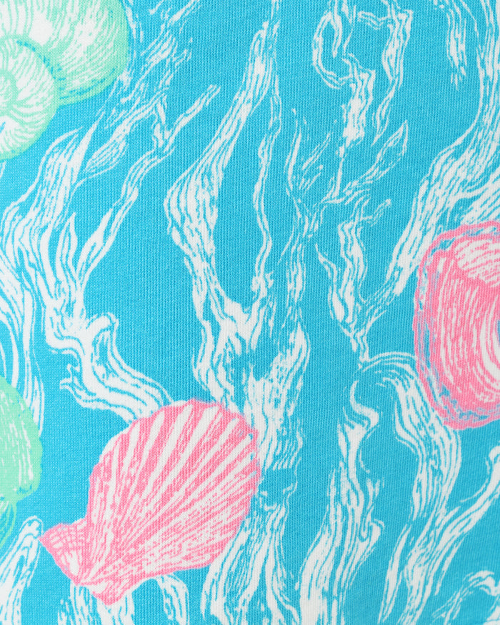 Blue dress pattern with teal and pink seashell details up close