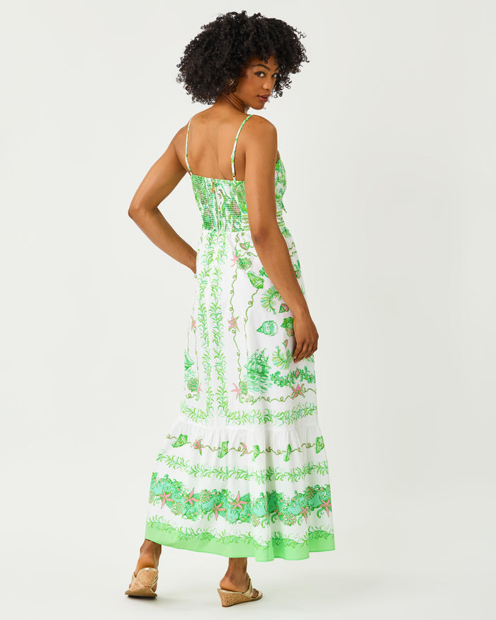 Woman wearing a green and white floral dress with front tie on a white background
