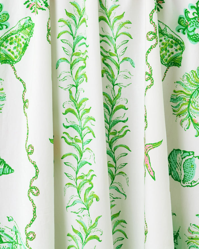 White dress pattern with green details of shells and plants up close