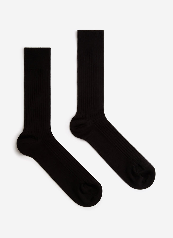 A pair of black Percival Loafer Dress Socks, showing their ribbed texture, laid flat against a white background.