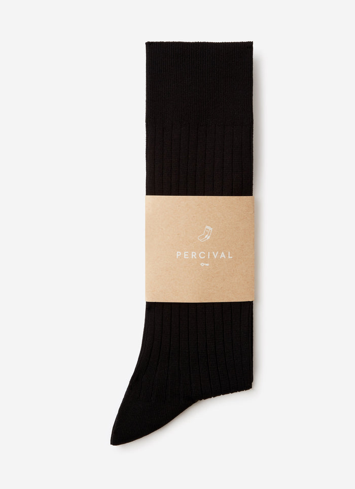 A pair of black ribbed Loafer Dress Socks by Percival, folded neatly in their branded cardboard sleeve.