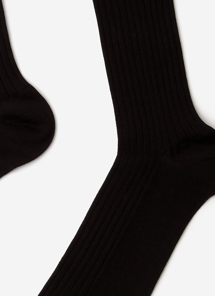 A close-up studio shot of the black ribbed cotton-blend Loafer Dress Socks by Percival, showing the fabric's texture.