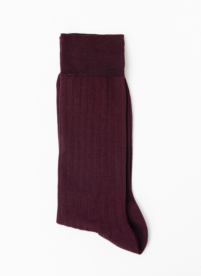 A single Percival Loafer Dress Sock in merlot, folded to display the ribbed cotton texture against a white background.