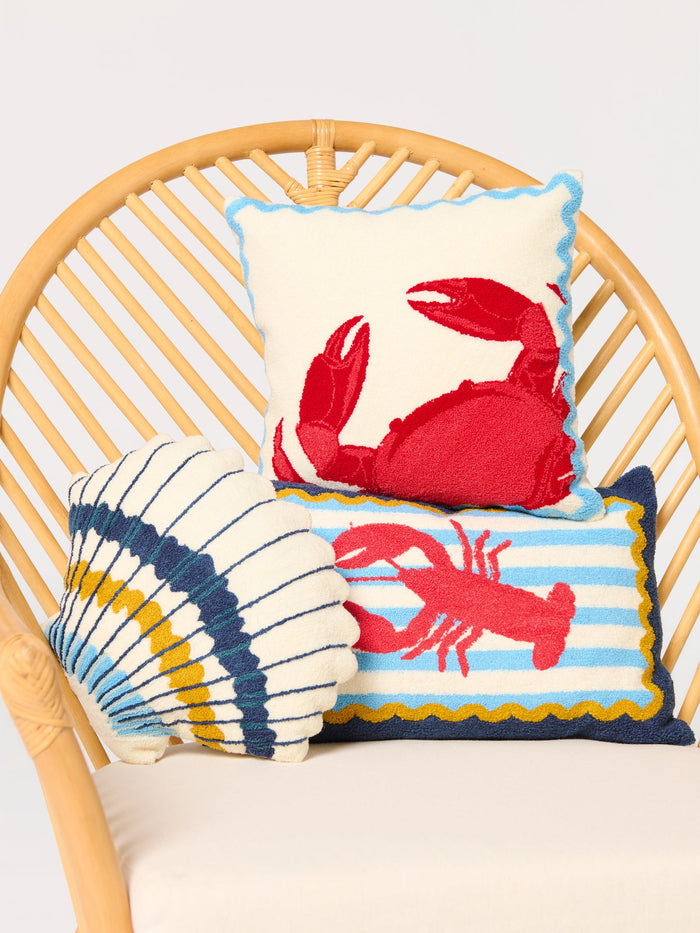 Decorative navy pillow with a red lobster on a blue and white striped background with golden yellow trim