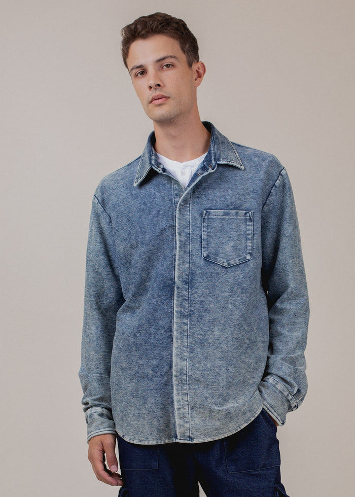 man wearing long sleeve indigo button down in mineral wash