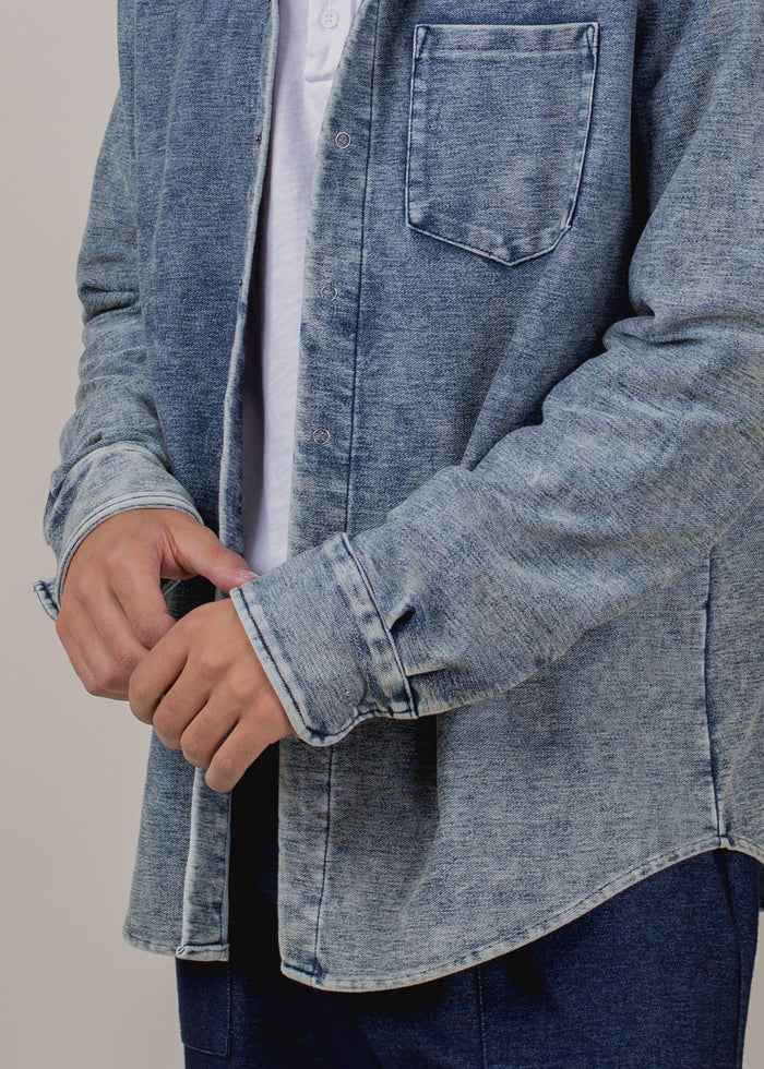 close up of man wearing long sleeve indigo button down in mineral wash