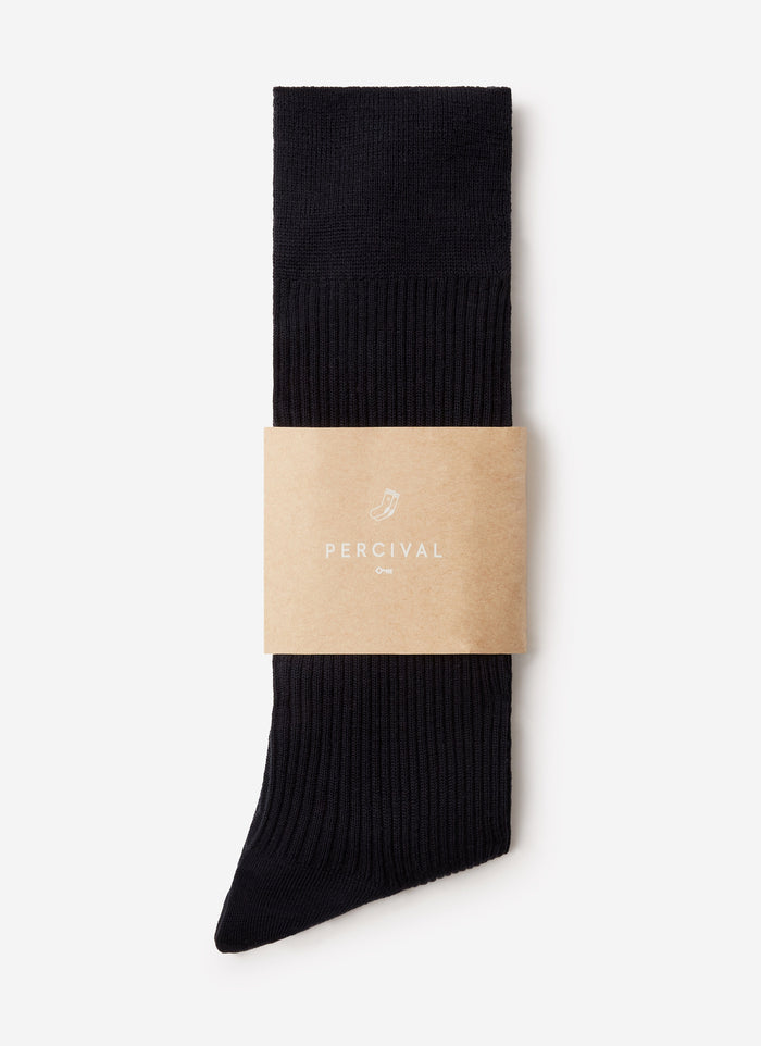 The navy ribbed Merino Wool Socks from Percival, folded and presented in their branded cardboard sleeve.