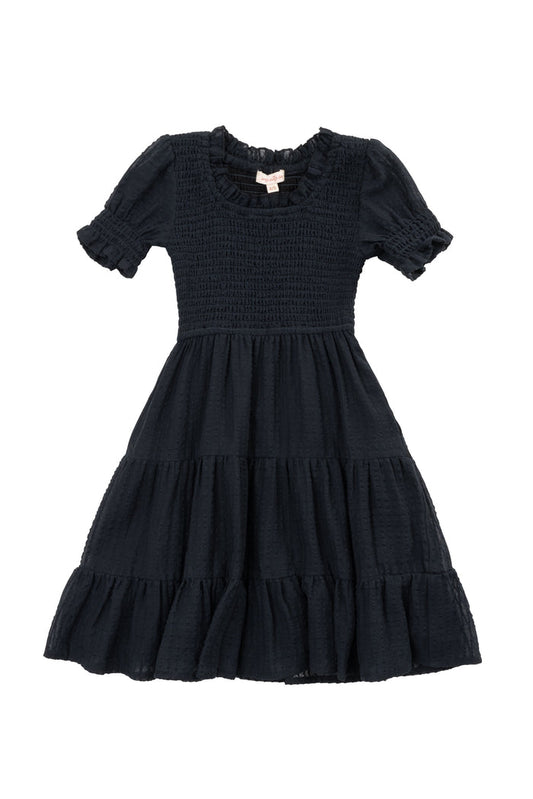 The Mini Ellery Dress in Black by Ivy City Co is a kids’ knee-length, short-sleeved dress with a smocked bodice, ruffled round neckline, tiered skirt, and ruffle trim—ideal for matching mom moments.